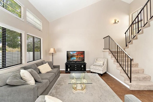 8556 Baldy Vista Dr, Rancho Cucamonga, CA 91730 - living area featuring dark tile patterned floors, high vaulted ceiling, stairway, and baseboards