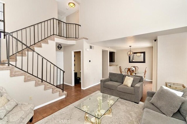 8556 Baldy Vista Dr, Rancho Cucamonga, CA 91730 - living room with tile patterned floors, stairs, a towering ceiling, and baseboards