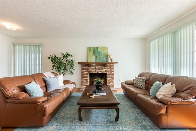 living room featuring plenty of natural light, a fireplace, dark hardwood / wood-style flooring, and a textured ceiling