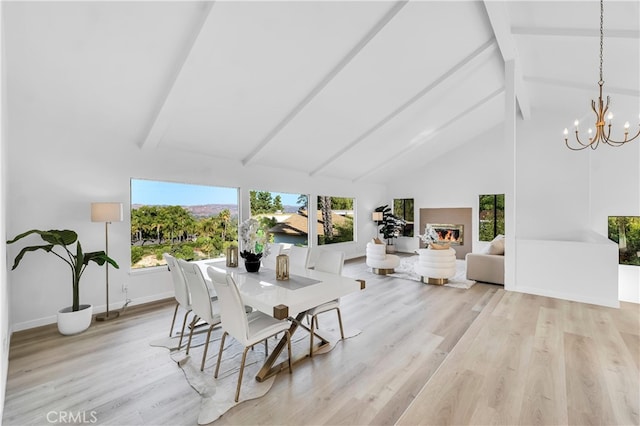 dining area with beamed ceiling, light wood-type flooring, a wealth of natural light, and high vaulted ceiling