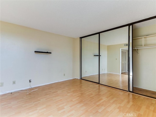 1923 Molino Ave Unit 303, Signal Hill, CA 90755 - unfurnished bedroom with light wood-type flooring, baseboards, and two closets