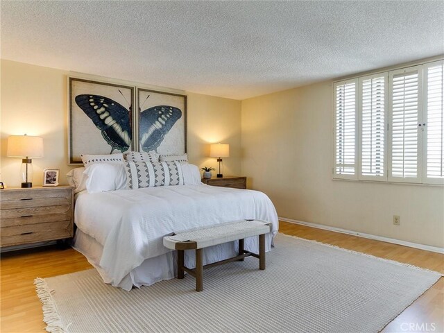 1923 Molino Ave Unit 303, Signal Hill, CA 90755 - bedroom featuring a textured ceiling, multiple windows, wood finished floors, and baseboards