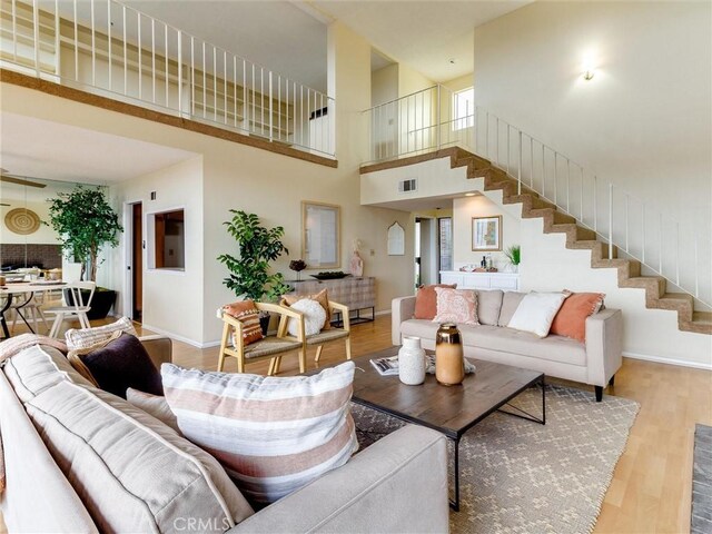 1923 Molino Ave Unit 303, Signal Hill, CA 90755 - living area featuring stairway, wood finished floors, baseboards, and a towering ceiling