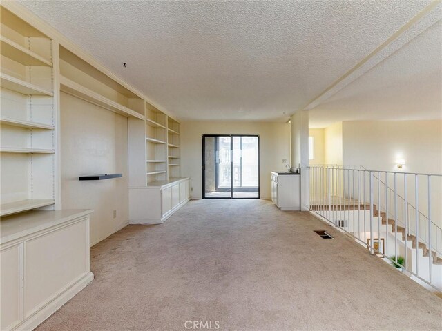 1923 Molino Ave Unit 303, Signal Hill, CA 90755 - empty room with carpet floors, a textured ceiling, built in shelves, and baseboards