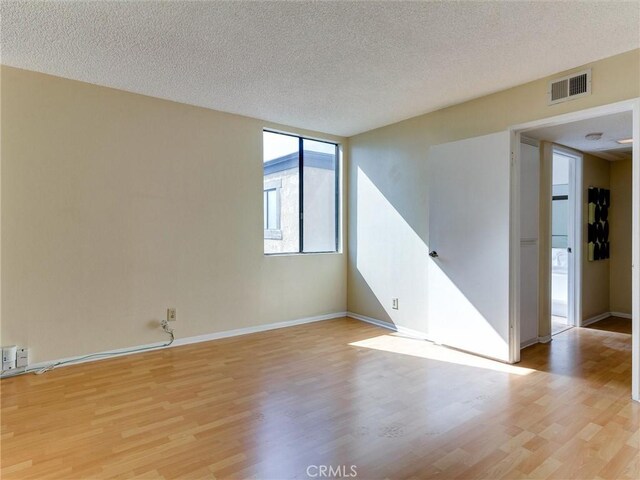 1923 Molino Ave Unit 303, Signal Hill, CA 90755 - unfurnished room with light wood finished floors, a textured ceiling, and baseboards