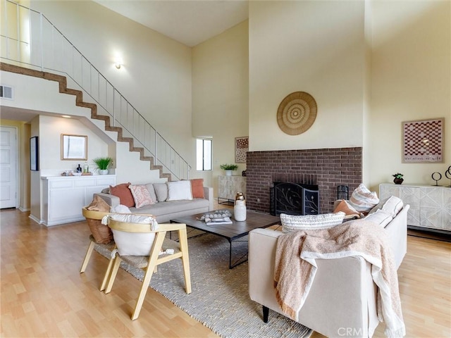 1923 Molino Ave Unit 303, Signal Hill, CA 90755 - living room featuring a high ceiling, light wood-style floors, a fireplace, and stairway
