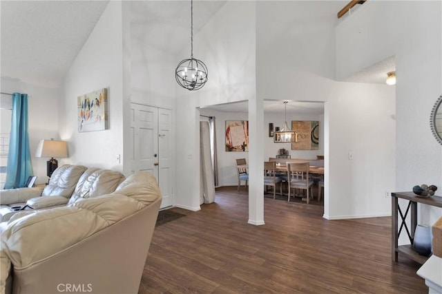 living room with an inviting chandelier, dark wood-type flooring, and high vaulted ceiling