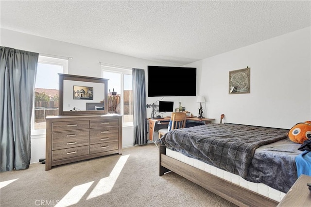 bedroom with light colored carpet and a textured ceiling