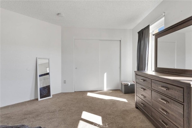 unfurnished bedroom featuring light carpet, a textured ceiling, and a closet