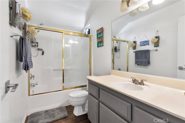 full bathroom featuring vaulted ceiling, hardwood / wood-style floors, shower / bath combination with glass door, vanity, and toilet