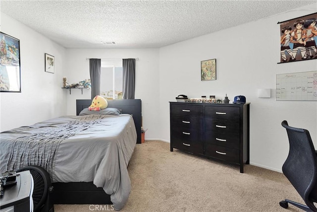 bedroom featuring light carpet and a textured ceiling