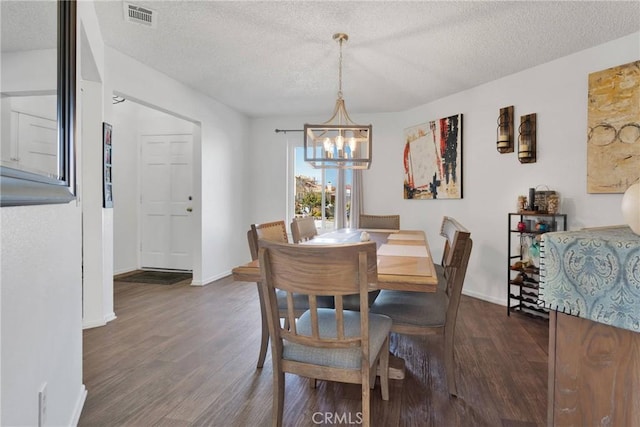 dining space with a notable chandelier, a textured ceiling, and dark hardwood / wood-style flooring