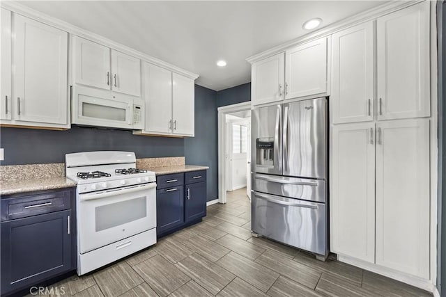 kitchen with white cabinetry, white appliances, and blue cabinetry