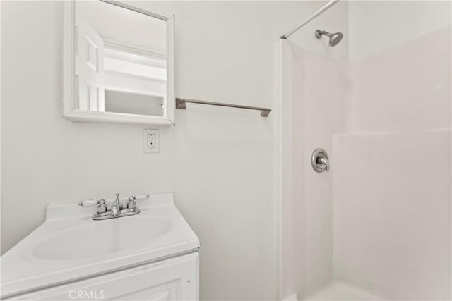 bathroom featuring walk in shower and vanity