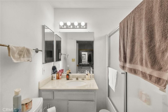 full bathroom with shower / bath combination with glass door, vanity, and toilet