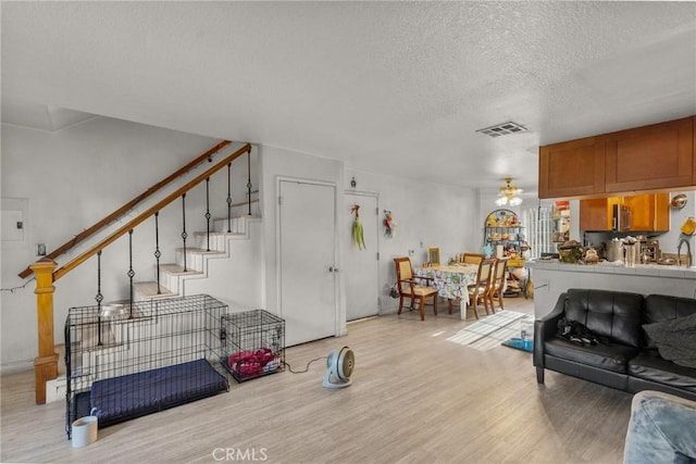 living room with light hardwood / wood-style flooring and a textured ceiling