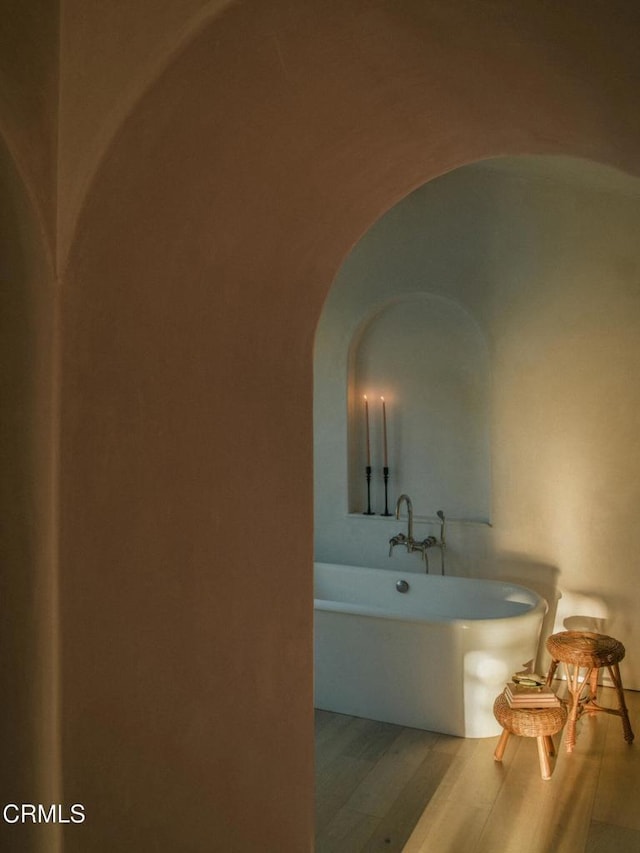 bathroom with hardwood / wood-style flooring and a bathing tub