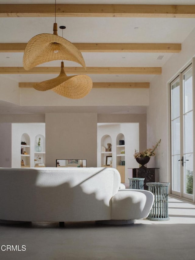 living room featuring beamed ceiling and built in features