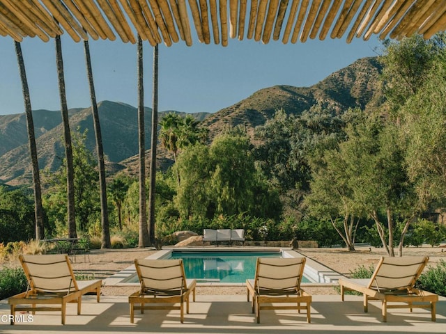 view of pool featuring a mountain view and a patio area