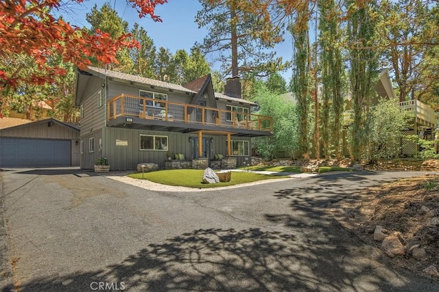 front of property featuring an outbuilding, a garage, and a front lawn