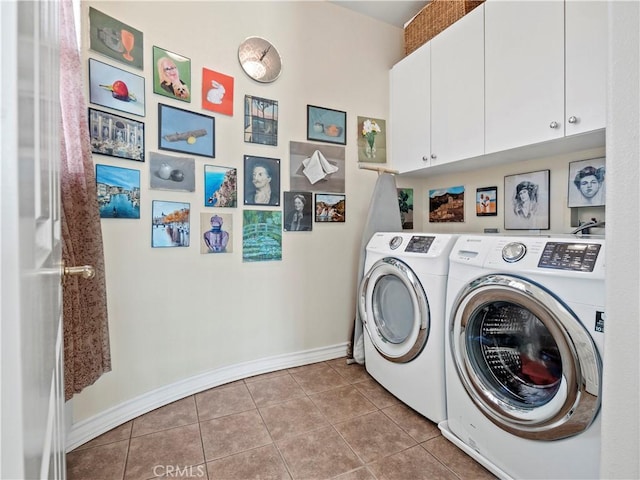 laundry room with light tile patterned floors, washer and clothes dryer, and cabinets