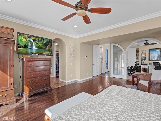 bedroom featuring ornamental molding, a walk in closet, hardwood / wood-style floors, and ceiling fan