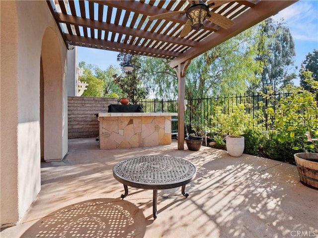 view of patio / terrace featuring exterior bar, ceiling fan, and a pergola