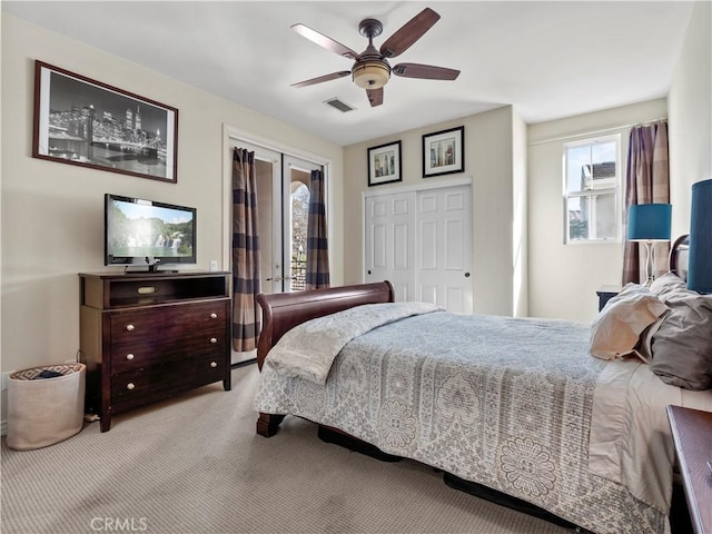 bedroom featuring ceiling fan, light colored carpet, and a closet