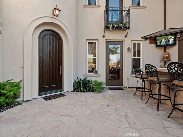 property entrance featuring a patio area and a bar