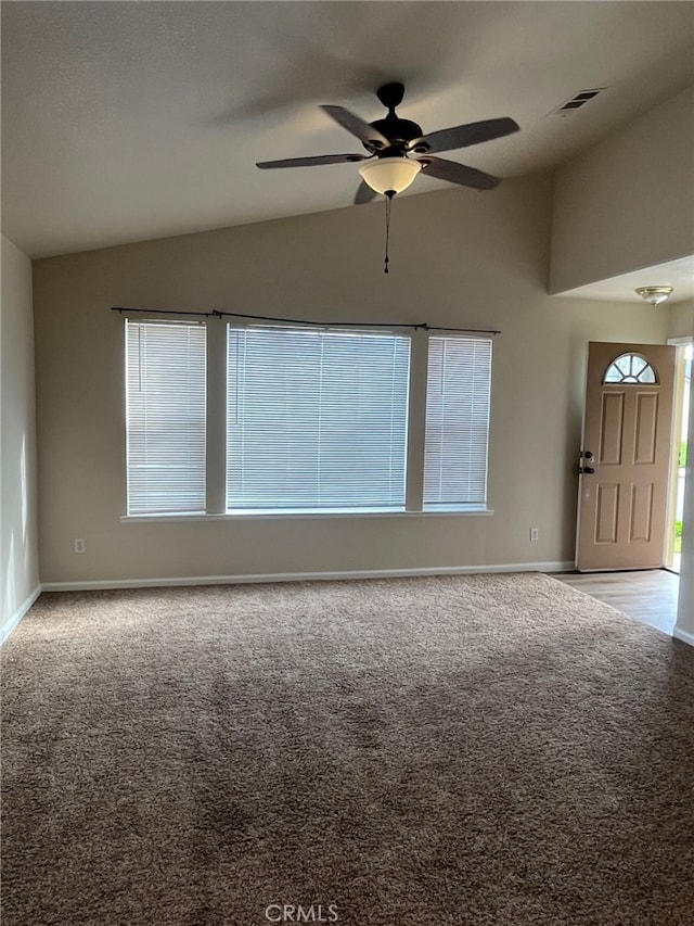 carpeted empty room with vaulted ceiling and ceiling fan