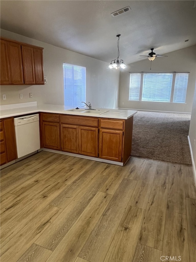 kitchen featuring sink, decorative light fixtures, white dishwasher, kitchen peninsula, and light hardwood / wood-style floors