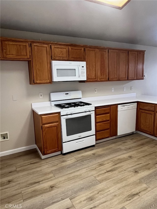 kitchen featuring white appliances and light hardwood / wood-style flooring