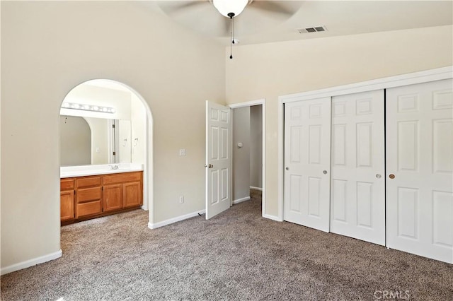 713 Vista Del Rey Dr, Atwater, CA 95301 - unfurnished bedroom with carpet flooring, a closet, arched walkways, ceiling fan, and ensuite bath
