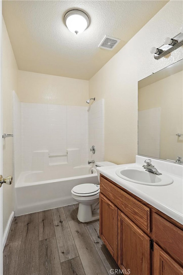713 Vista Del Rey Dr, Atwater, CA 95301 - full bath featuring wood finished floors, vanity, a textured ceiling, and bathing tub / shower combination