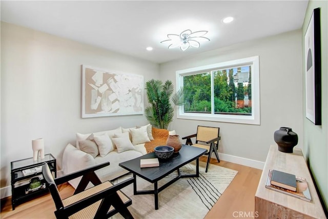 living room with light wood-type flooring, baseboards, and recessed lighting