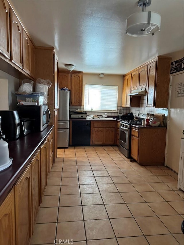 kitchen with tasteful backsplash, appliances with stainless steel finishes, sink, and light tile patterned floors