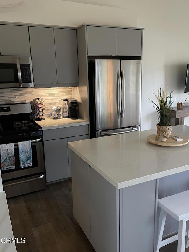 kitchen with gray cabinets, appliances with stainless steel finishes, and light countertops