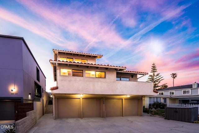 mediterranean / spanish-style house featuring concrete driveway, stairway, an attached garage, and stucco siding