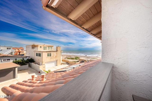 balcony featuring a water view and a view of the beach