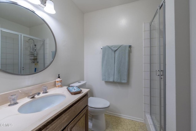 full bath featuring vanity, a shower stall, toilet, and baseboards