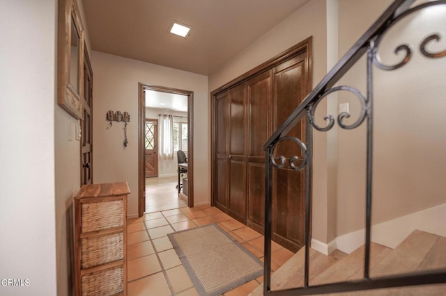 interior space with light tile patterned flooring and baseboards