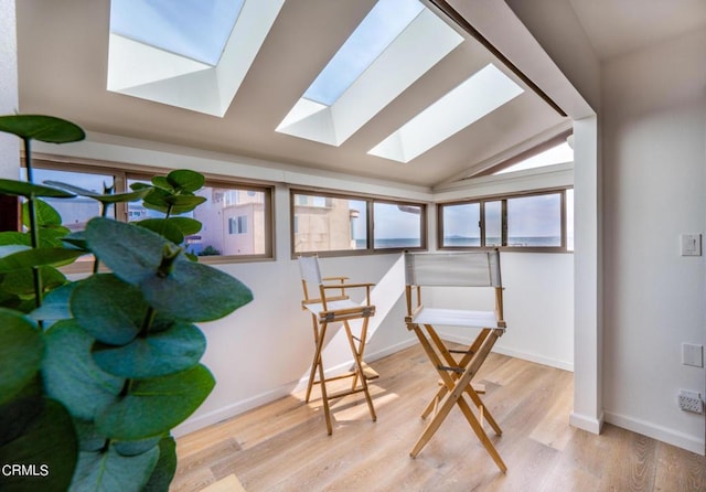 sunroom featuring vaulted ceiling with skylight