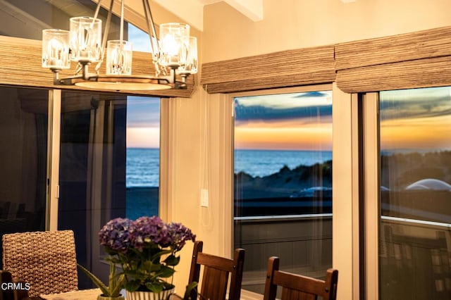 dining area with a water view and a notable chandelier