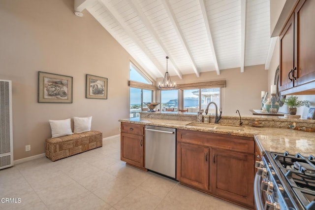 kitchen featuring a sink, appliances with stainless steel finishes, light stone countertops, beamed ceiling, and pendant lighting