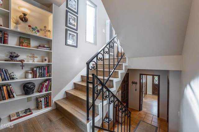 staircase featuring built in shelves and wood finished floors