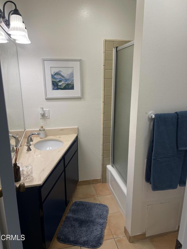 full bath with enclosed tub / shower combo, vanity, baseboards, and tile patterned floors