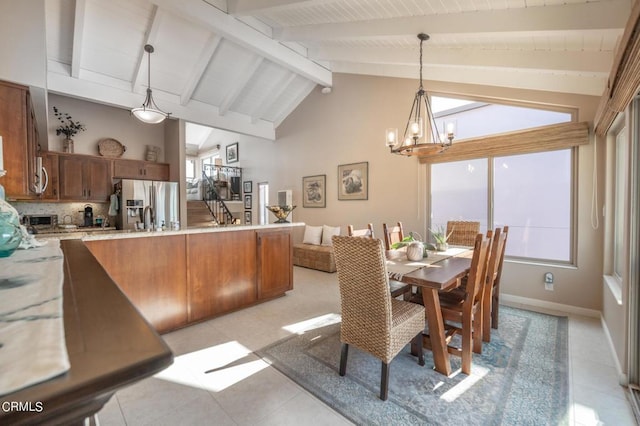 dining room with a toaster, a notable chandelier, baseboards, stairway, and beam ceiling