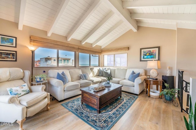 living area with lofted ceiling with beams and light wood finished floors