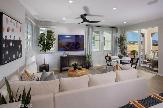 living room with light hardwood / wood-style floors and ceiling fan