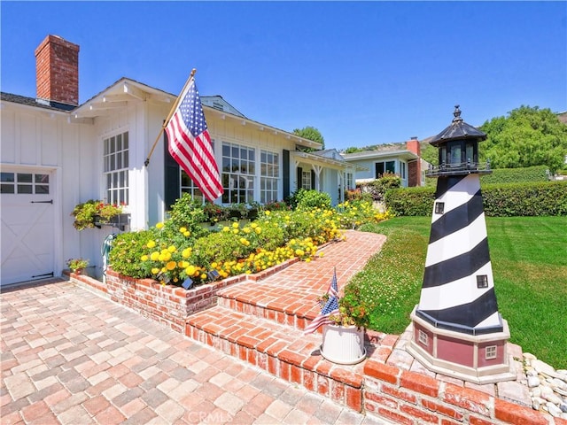 view of front of home with a garage and a front lawn